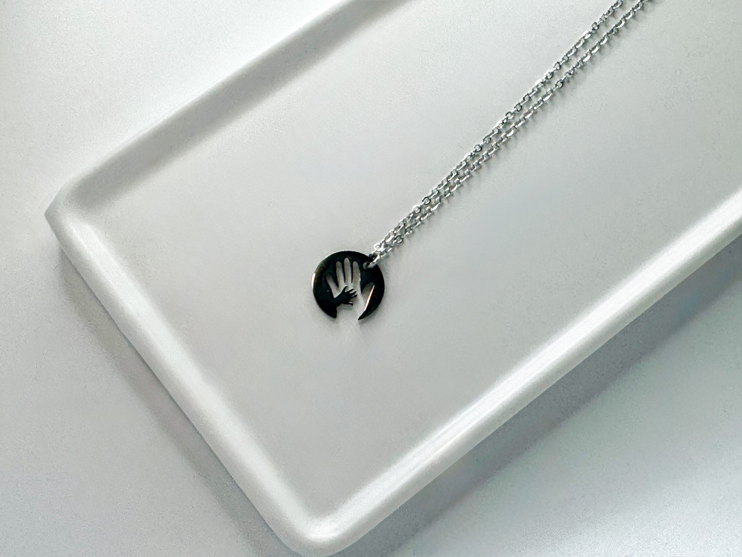 Stainless “hand in mine” necklace